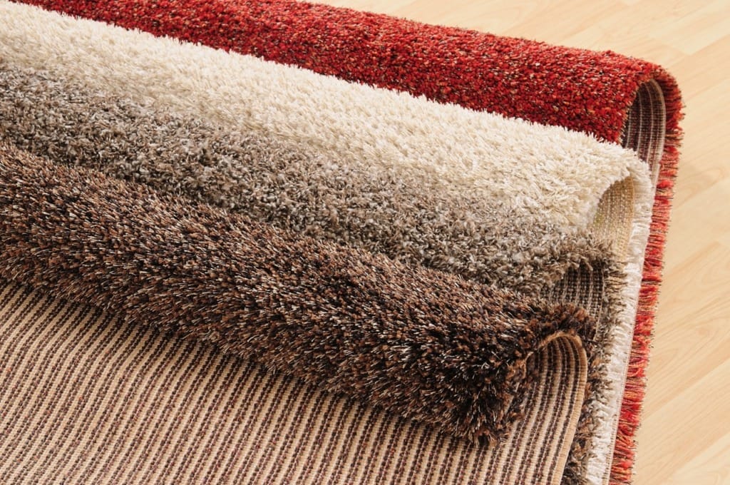 Rolled carpets showing latex-free alternatives in various colors and textures