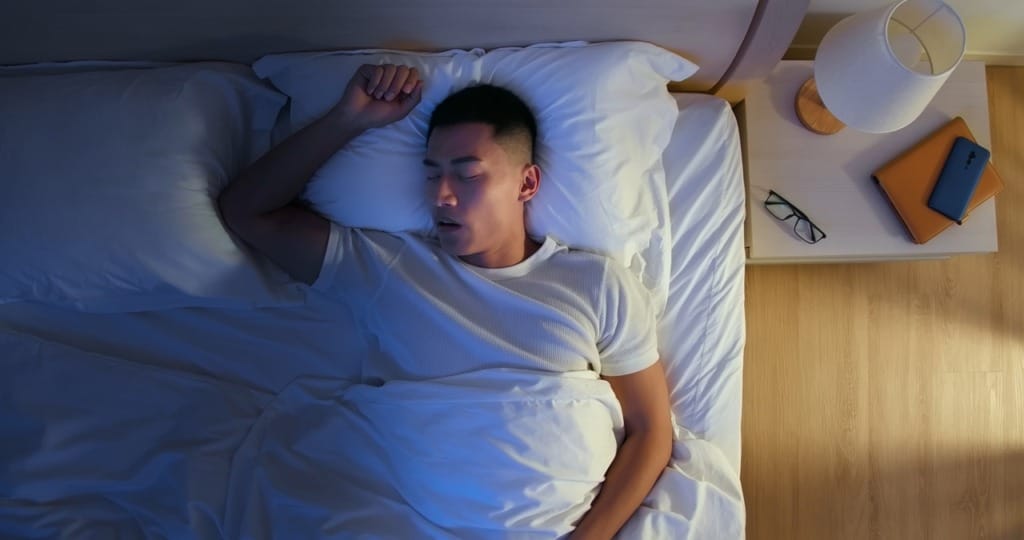 Man sleeping restlessly at night due to allergy symptoms disrupting sleep
