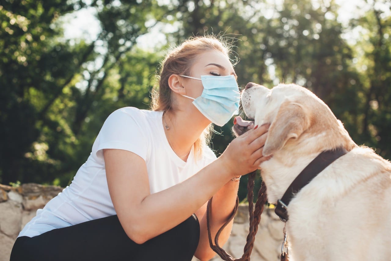 Woman wearing mask near dog during allergy season