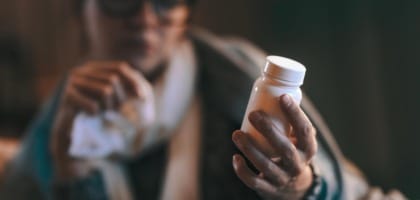 Person holding over the counter allergy medication bottle